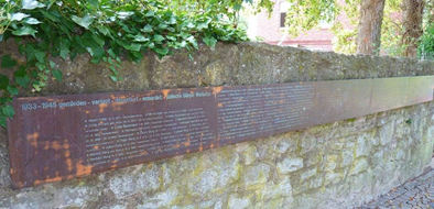 Vor dem Friedhof wurden entlang der Mauer 1995 Erinnerungstafeln mit den Namen der deportierten jüdischen Einwohner Warburgs angebracht.